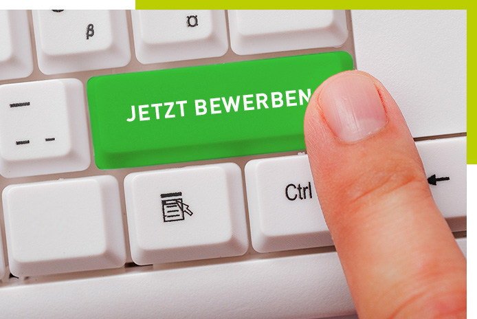 Eine weiße Computertastatur mit einer auffälligen grünen Taste, auf der in weißer Schrift ‚JETZT BEWERBEN‘ steht. Ein Finger berührt die Taste, als würde er sie drücken.